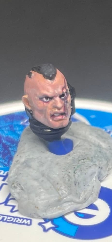 A characterful painted head on a sculpting base